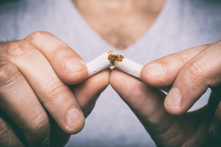 Χέρια που σπάνε ένα τσιγάρο – συμβολισμός διακοπής καπνίσματος