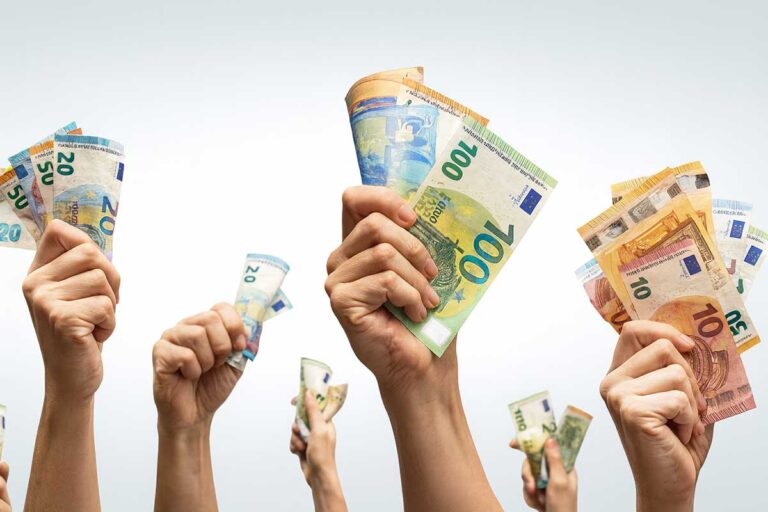 Χέρια υψώνουν χαρτονομίσματα ευρώ, συμβολίζοντας μεγάλα χρηματικά ποσά και επιδοτήσεις