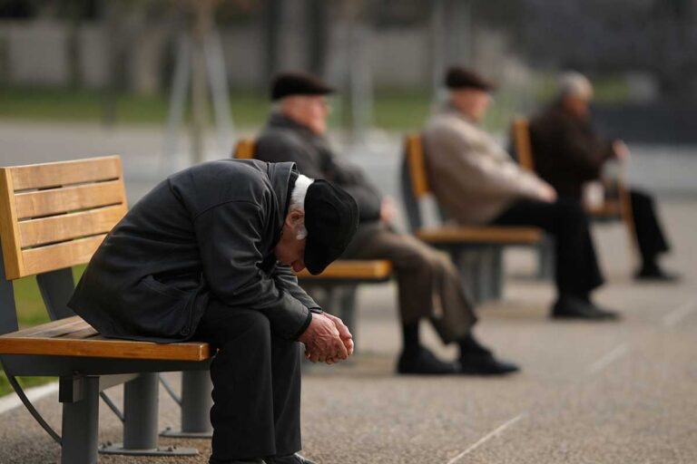 Ηλικιωμένοι άνδρες καθισμένοι σε παγκάκια σε δημόσιο χώρο, με έμφαση στη γήρανση του πληθυσμού στην Ελλάδα