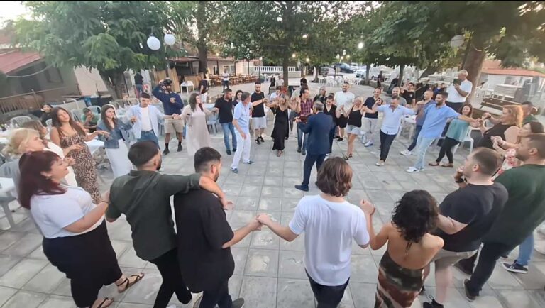 Κάτοικοι και επισκέπτες χορεύουν σε κύκλο στην πλατεία του Λιοπράσου Τρικάλων κατά τη δημοτική βραδιά 2025