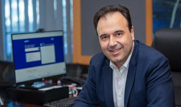 Ο Υπουργός Ψηφιακής Διακυβέρνησης Δημήτρης Παπαστεργίου στο γραφείο του, μπροστά από οθόνη με ανοιχτό το gov.gr και τη λειτουργία του ψηφιακού βοηθού mAigov.