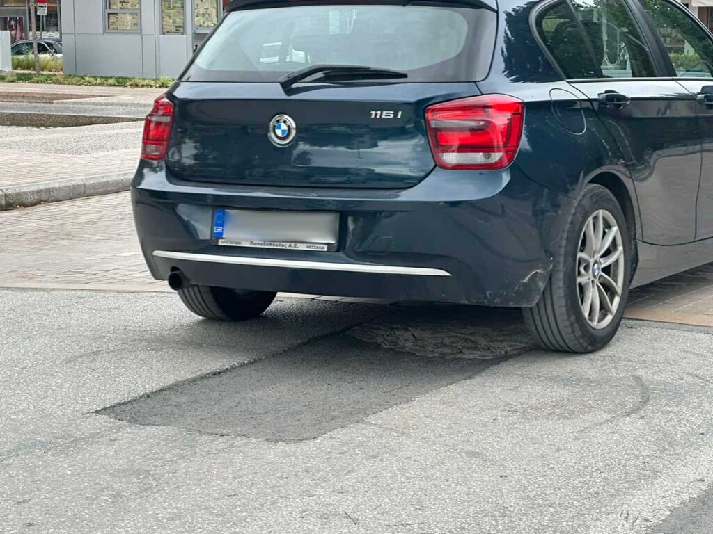 Αυτοκίνητο περνά πάνω από λακούβα στη διάβαση της πλατείας