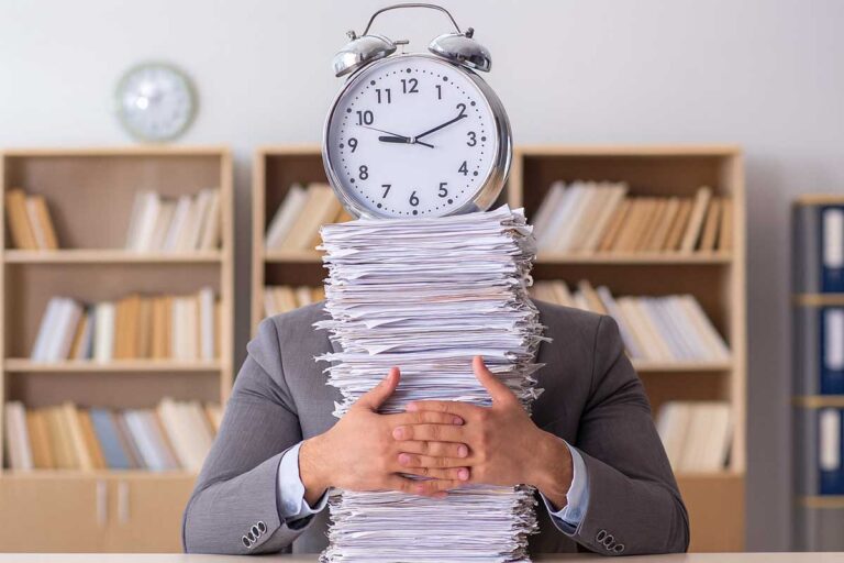Δημόσιος υπάλληλος με στοίβα φακέλων και ρολόι, συμβολική εικόνα για συνταξιοδότηση και γραφειοκρατία
