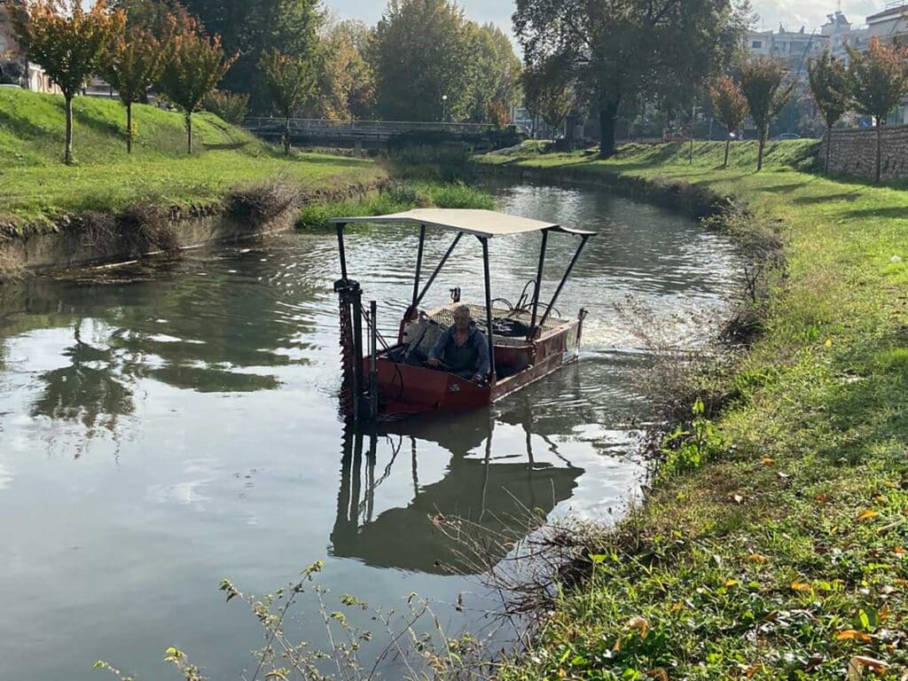 Εργασίες καθαρισμού της κοίτης του Ληθαίου από συνεργείο του Δήμου Τρικκαίων με ειδικό σκάφος και προσωπικό μέσα στο ποτάμι