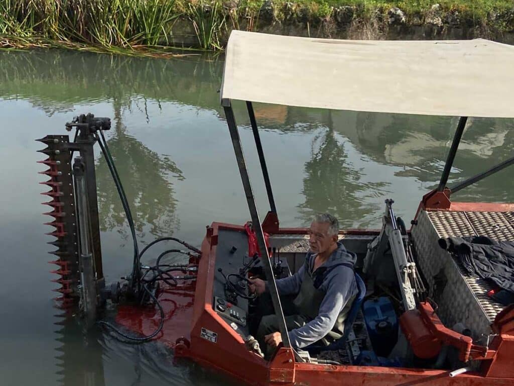 Εργασίες καθαρισμού της κοίτης του Ληθαίου από συνεργείο του Δήμου Τρικκαίων με ειδικό σκάφος και προσωπικό μέσα στο ποτάμι