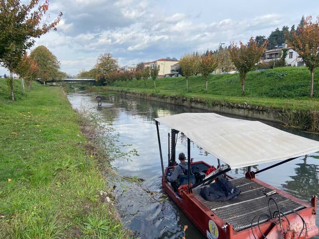 Εργασίες καθαρισμού της κοίτης του Ληθαίου από συνεργείο του Δήμου Τρικκαίων με ειδικό σκάφος και προσωπικό μέσα στο ποτάμι