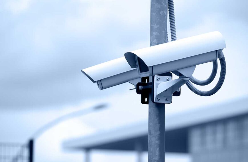 Κάμερα επιτήρησης εγκατεστημένη σε μεταλλικό στύλο σε εξωτερικό χώρο.