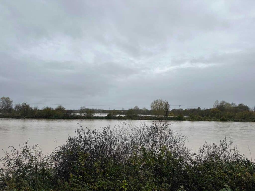 Ο Πηνειός ποταμός με υψηλή στάθμη νερού από Μεγάλα Καλύβια έως Γλίνος, με εκτεταμένη πλημμυρική εικόνα γύρω από τα αναχώματα και τη γέφυρα του Ε65.